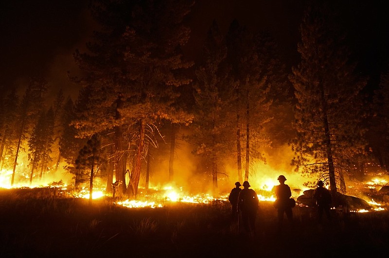 FILE - In this Sept. 1, 2021, file photo, a firefighter lights a backfire to stop the Caldor Fire from spreading near South Lake Tahoe, Calif.(AP Photo/Jae C. Hong, File)