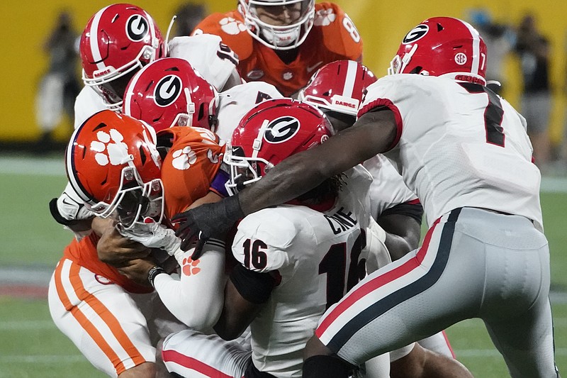 Clemson quarterback D.J. Uiagalelei is tackled by Georgia defensive back Lewis Cine (16) and other defenders during the second half of an NCAA college football game Saturday, Sept. 4, 2021, in Charlotte, N.C. (AP Photo/Chris Carlson)


