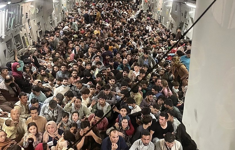 Photo by Capt. Chris Herbert, U.S. Air Force via AP / Afghan citizens pack inside a U.S. Air Force C-17 Globemaster III, as they are transported from Hamid Karzai International Airport in Afghanistan on Aug. 15, 2021.
