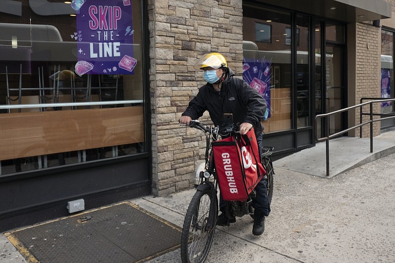 FILE - In this April 21, 2021 file photo, a delivery man bikes with a food bag from Grubhub in New York. (AP Photo/Mark Lennihan, File)


