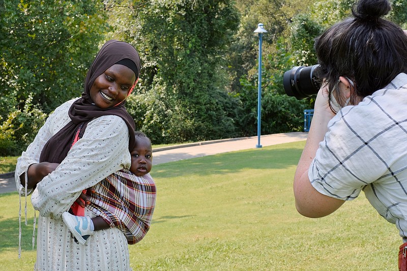 Staff photo by Wyatt Massey / Salwa Ibrahim stands with her 11-month-old son Mousa in Riverpoint Park on Saturday, Sept. 11, 2021, while Brooke Bragger takes their picture. The family portrait day was hosted by the Chattanooga chapter of the Trust of Public Land.