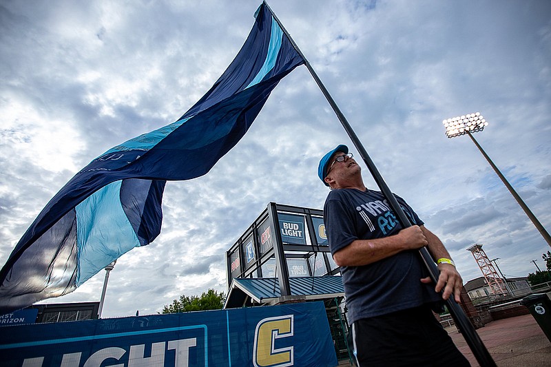 Staff photo by Troy Stolt / Chattahooligan fan group member David Adams holds a giant Chattanooga Football Club flag during the professional soccer team's match against Appalachian FC on July 7 at Finley Stadium.