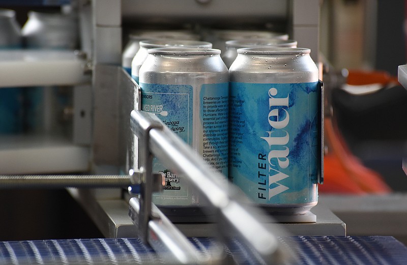 Staff Photo by Matt Hamilton / Cans of water come off the line at Naked River Brewing on Monday. Naked River Brewing joined forces with other local breweries Monday, Sept. 13, 2021, to produce canned water to send to Louisiana for victims of Hurricane Ida.