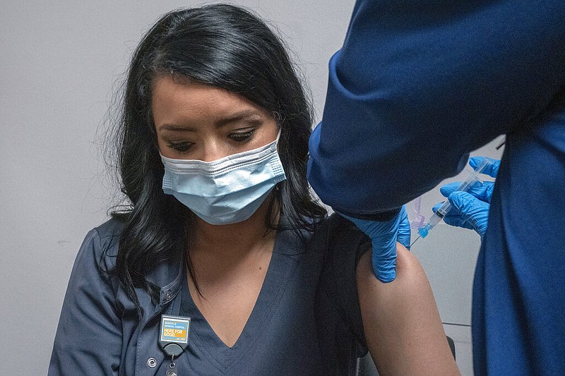 Health care worker and new employee Amber Blunk gets her first COVID-19 vaccination from Lauren Franklin at Nashville General Hospital in Nashville, Tenn., Friday, Aug. 20, 2021. This was her first shot. (AP Photo/John Partipilo)