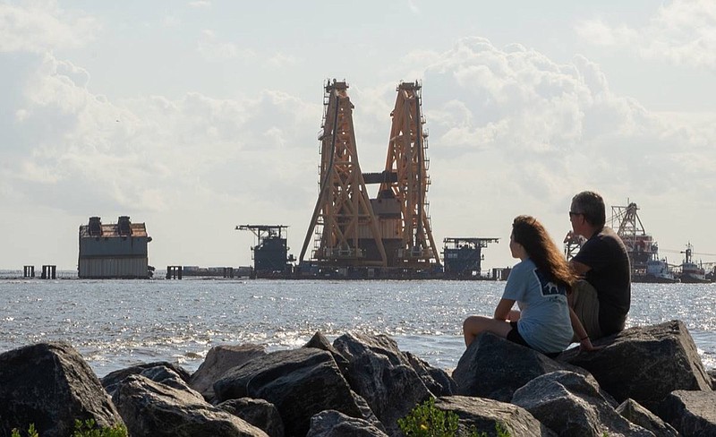 A towering crane straddles remains of the shipwrecked cargo vessel Golden Ray in the waters off St. Simons Island, Ga., on Sunday, Sept. 5, 2021. (Terry Dickson/The Brunswick News via AP)


