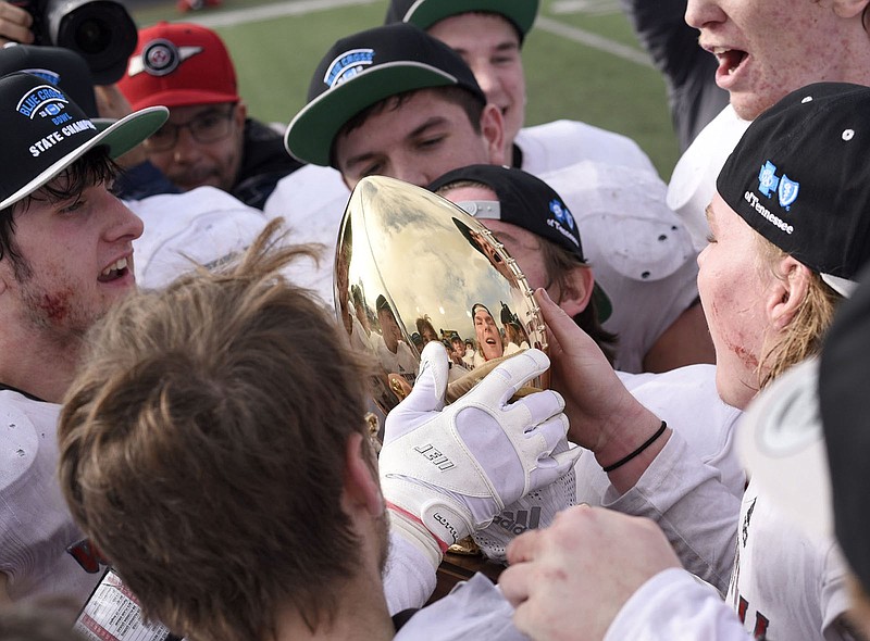 Staff photo by Robin Rudd / Hudson Petty, left, holds the championship trophy as Josh Wingo, right, prepares to kiss it after the Whitwell Tigers beat Connersville 7-6 to win the TSSAA Class 1A football state title in December 2018 at Tennessee Tech.