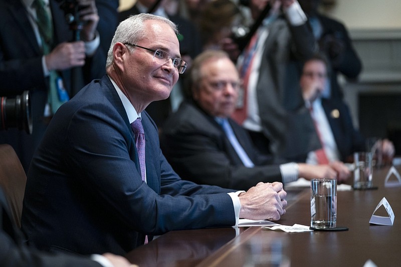 FILE - In this April 3, 2020, file photo Exxon Mobil CEO Darren Woods listens as President Donald Trump speaks during a meeting with energy sector business leaders in the Cabinet Room of the White House in Washington. Congressional Democrats are calling top executives at ExxonMobil and other oil giants to testify at a House hearing as lawmakers investigate what they say is a long-running, industry-wide campaign to spread disinformation about the role of fossil fuels in causing global warming. (AP Photo/Evan Vucci, File)