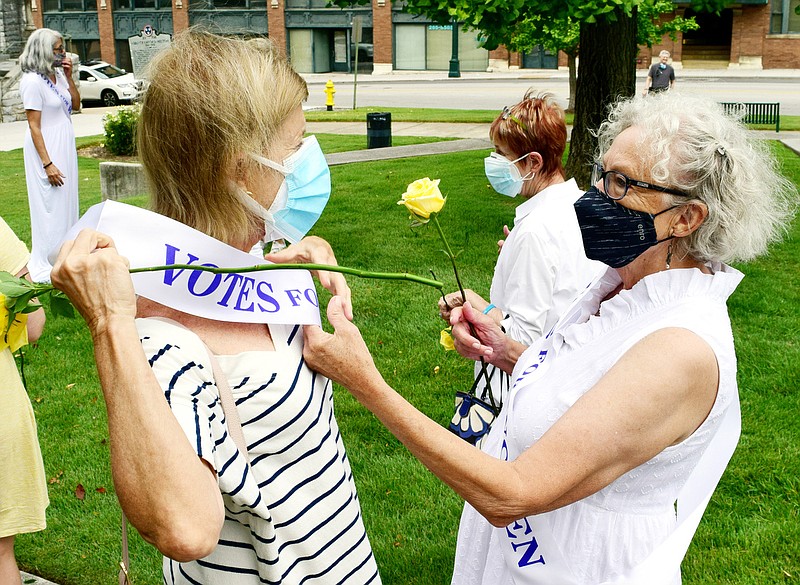 Staff Photo by Robin Rudd / Linda Rudder, right, helps Dorothy Hallman with her sash before the program. The League of Women Voters of Chattanooga held a dedication ceremony on Friday, Sept. 17, 2021, to celebrate suffragist Abby Crawford Milton's work across the state for passage of the 19th amendment, ultimately winning women the right to vote. The ceremony was held in Philips Park at the corner of McCallie and Georgia Avenues where Milton's historical marker stands. The celebration included the installation of a plaque and park bench donated by the league. 