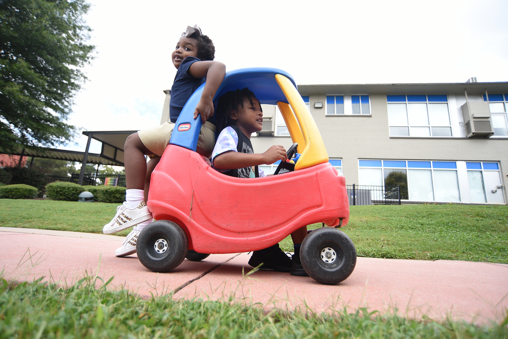 Staff Photo by Matt Hamilton / Josie Gaines rides on the back of a toy car as Darrien Boone, Jr. drives it on Thursday, September 16, 2021 at Signal Centers. Friends of Special Children is holding a fundraiser for playground equipment for Signal Centers.
