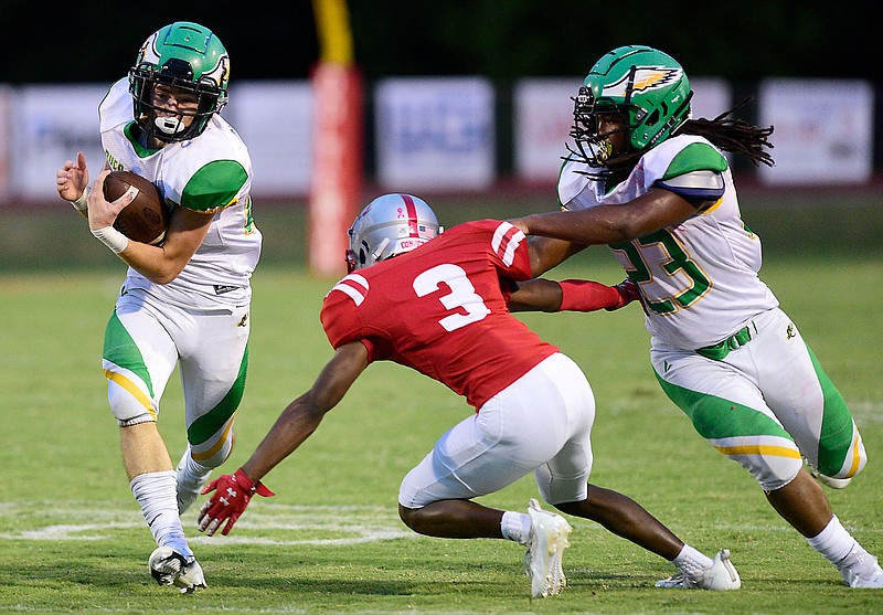 Staff photo by Robin Rudd / Rhea County's Briley Mayberry, left, picks up yardage outside as Latron Alloway, right, blocks Ooltewah's Jasen Carmicheal during Friday night's Region 4-5A game at Ooltewah.