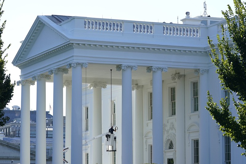 A worker works on the light fixture over the North Portico of the White House in Washington, Friday, Sept. 3, 2021. (AP Photo/Susan Walsh)


