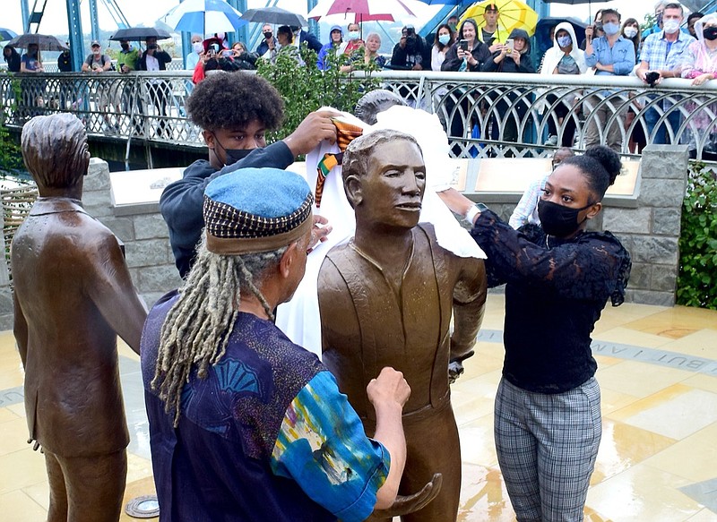 Staff Photo by Robin Rudd / Howard School students Roy Miles and Trinity Smith help sculptor Jerome Meadows unveil the figure of Ed Johnson. The two other figures are those of Noah Parden and Styles Hutchens, two African-American attorneys from Chattanooga, who provided a courageous and successful defense for Ed Johnson. The Ed Johnson Memorial was dedicated at the south side of the Walnut Street Bridge in Chattanooga on September 19, 2021. On March 19, 1906, Ed Johnson, was mob-lynched from the second span of the Walnut Street Bridge. Dr. Eddie Claude, Jr. was the keynote speaker during the unveiling of sculptor Jerome Meadows's work.