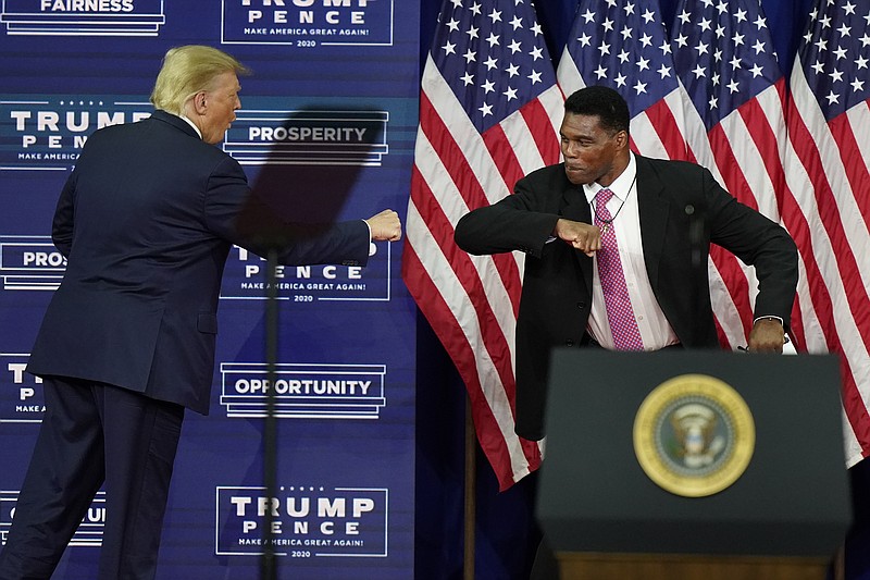 AP photo by John Bazemore / In this Sept. 25, 2020, file photo, President Donald Trump elbow bumps with Herschel Walker during a campaign rally in Atlanta.