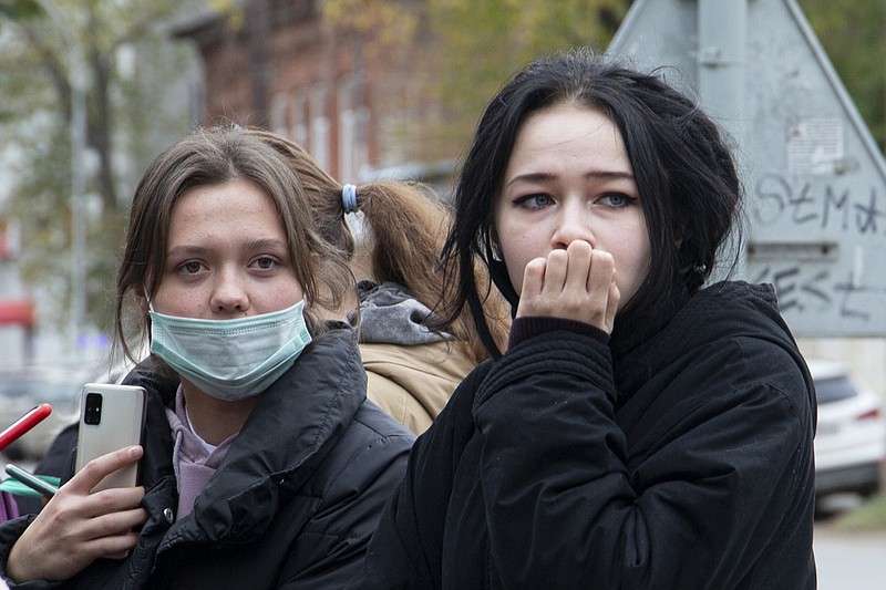 Students stand near the Perm State University in Perm, about 1,100 kilometers (700 miles) east of Moscow, Russia, Monday, Sept. 20, 2021. A gunman opened fire in a university in the Russian city of Perm on Monday morning, leaving at least eight people dead and others wounded, according to Russia's Investigative Committee. (AP Photo/Anastasia Yakovleva)