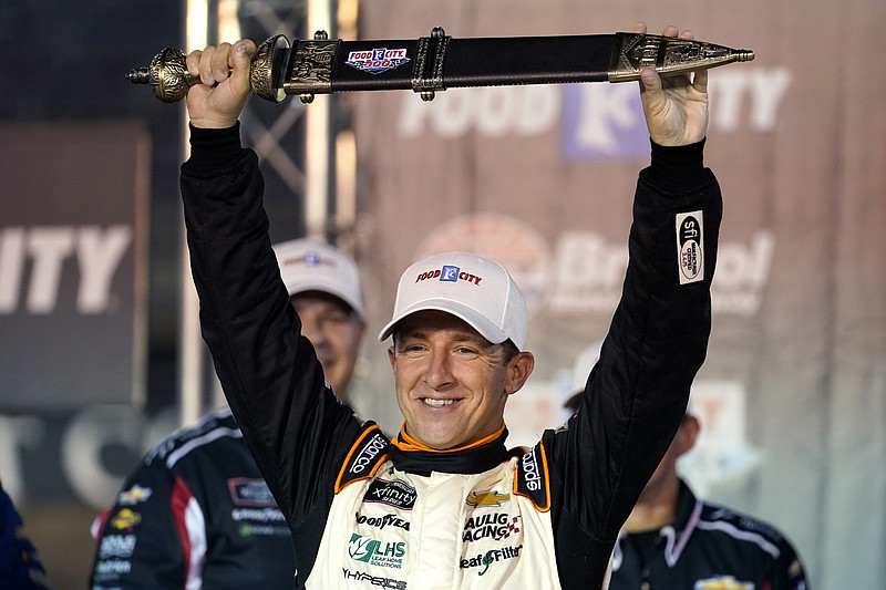 AJ Allmendinger holds up the winner's sword after a NASCAR Xfinity Series auto race at Bristol Motor Speedway Friday, Sept. 17, 2021, in Bristol, Tenn. (AP Photo/Mark Humphrey)