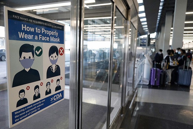 FILE - This July 2, 2021, file photo shows a sign stating face coverings are required is displayed at O'Hare airport in Chicago. Federal officials say unruly passengers are becoming a bit less common on airline flights, but they are still causing disruptions at twice the rate of late last year. The Federal Aviation Administration said Thursday, Sept, 23, the its zero-tolerance policy — including fines against more passengers — is helping. (AP Photo/Nam Y. Huh, File)