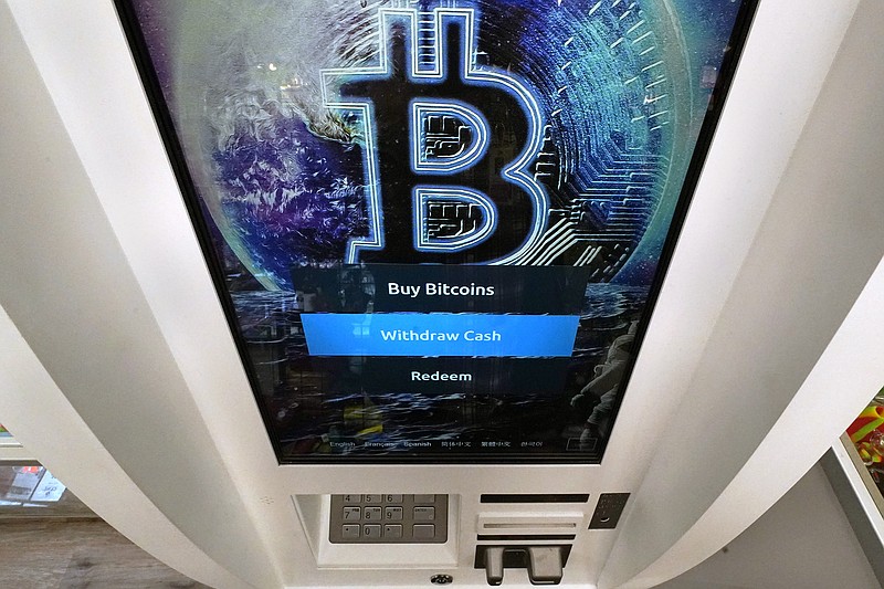 FILE - In this Feb. 9, 2021, file photo, the Bitcoin logo appears on the display screen of a cryptocurrency ATM at the Smoker's Choice store in Salem, N.H. China's central bank on Friday, Sept. 24, 2021, declared all transactions involving Bitcoin and other virtual currencies illegal, stepping up a campaign to block use of unofficial digital money. (AP Photo/Charles Krupa, File)