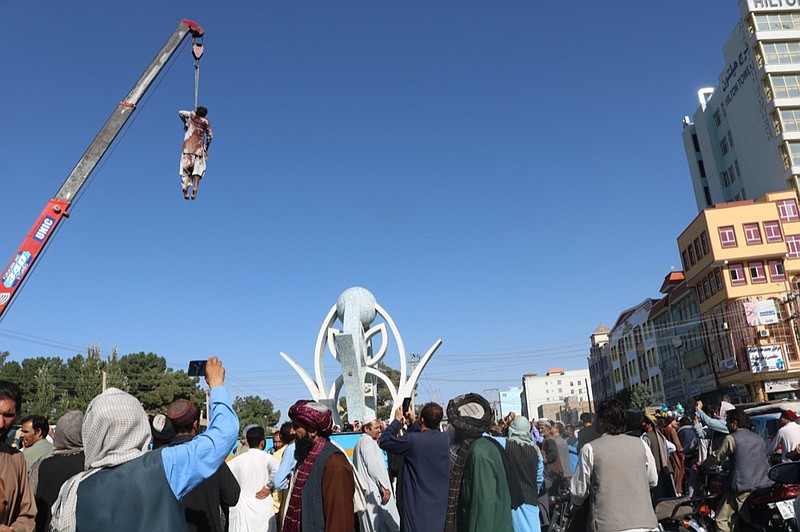 A dead body hangs from a crane in the main square of Herat city in western Afghanistan, on Saturday, Sept. 25, 2021. A witness told The Associated Press that the bodies of four men were brought to the main square and three of them were moved to other parts of the city for public display. The Taliban announced in the square that the four were caught taking part in a kidnapping and were killed by police. (AP Photo)


