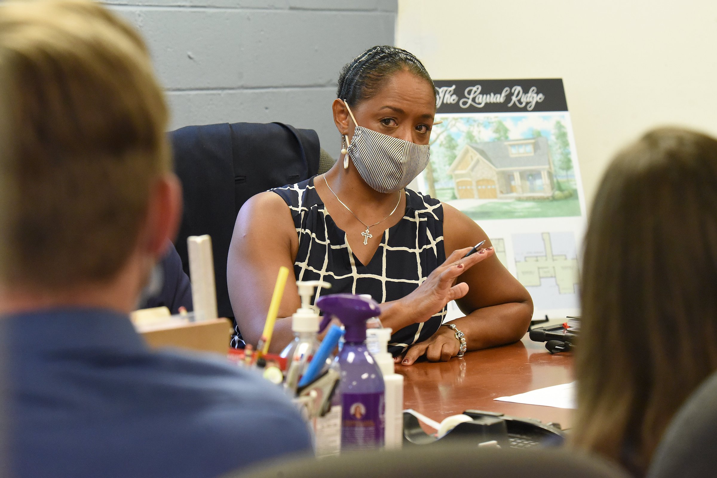 Staff Photo by Matt Hamilton / Brenda Jean Adamson talks with Shane and Kaley Tretheway during a meeting at the Adamson Builders office on Brainerd Road in August.