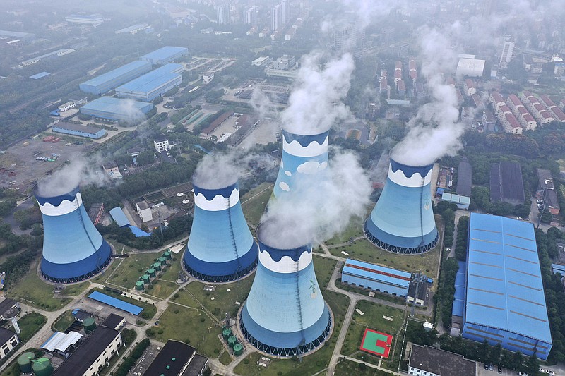 Steam billows out of the cooling towers at a coal-fired power station in Nanjing in east China's Jiangsu province on Monday, Sept. 27, 2021. Global shoppers face possible shortages of smartphones and other goods ahead of Christmas after power cuts to meet government energy use targets forced Chinese factories to shut down and left some households in the dark. (Chinatopix via AP)