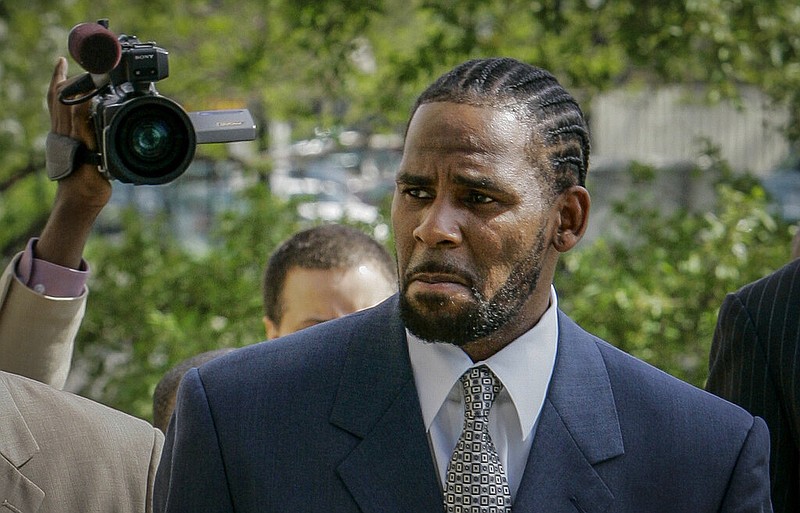 This photo from Friday May 9, 2008, shows R. Kelly arriving for the first day of jury selection in his child pornography trial at the Cook County Criminal Courthouse in Chicago. R. Kelly, the R&B superstar known for his anthem "I Believe I Can Fly," was convicted Monday in a sex trafficking trial after decades of avoiding criminal responsibility for numerous allegations of misconduct with young women and children. (AP Photo/Charles Rex Arbogast, File)