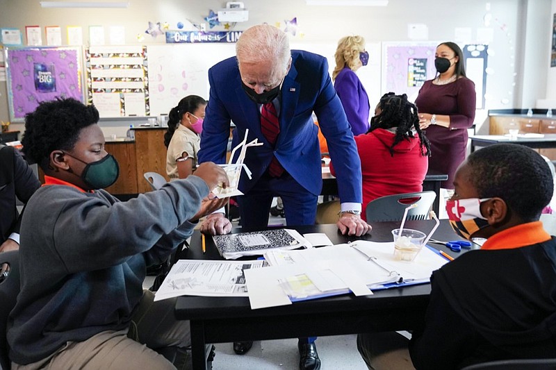 FILE - In this Sept. 10, 2021, file photo President Joe Biden talks to students at Brookland Middle School in Washington, as first lady Jill Biden talks with Brookland Middle School science teacher Michelle Taylor, right rear. As Democrats push ahead with Biden's $3.5 trillion rebuilding plan, they are promising historic investments across all levels of education. The proposal includes universal prekindergarten, two years of free community college and expanded child care subsidies, among others. (AP Photo/Manuel Balce Ceneta, File)

