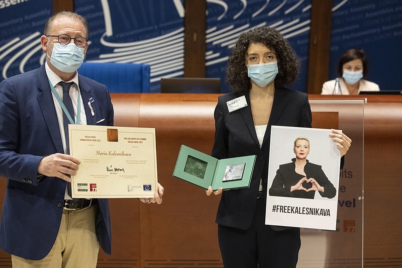 Parliamentary Assembly Rik Daems, left, holds a diploma while Tatiana Khomich holds a poster of jailed Belarus civil rights activist Maria Kalesnikava, who won the Vaclav Havel Human Rights Prize awarded at the Parliamentary Assembly of the Council of Europe, in Strasbourg, eastern France, Monday, Sept. 27, 2021. (AP Photo/Jean-Francois Badias)