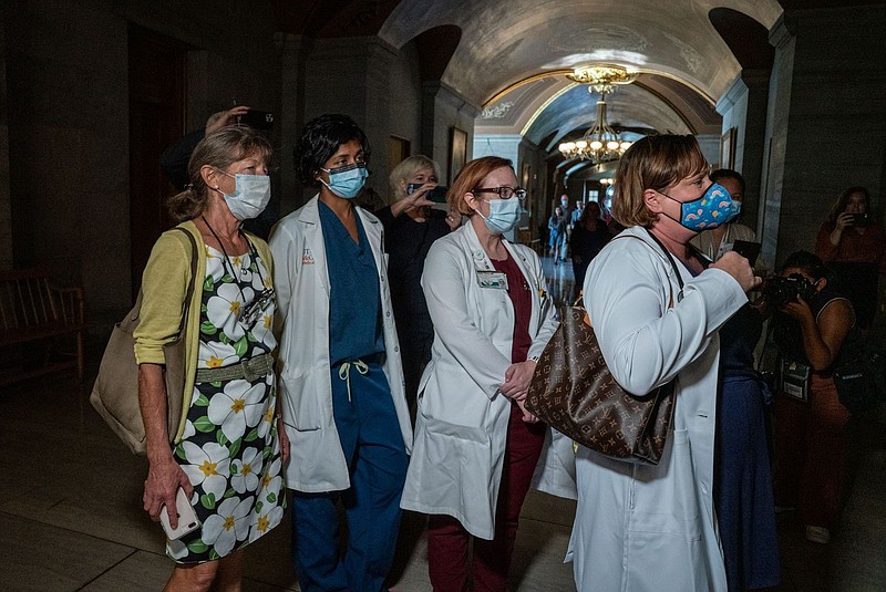 A group of doctors representing St. Jude's Children's Research Hospital attempt to get Gov. Bill Lee's attention after his Thursday press conference. / Tennessee Lookout photo by John Partipilo