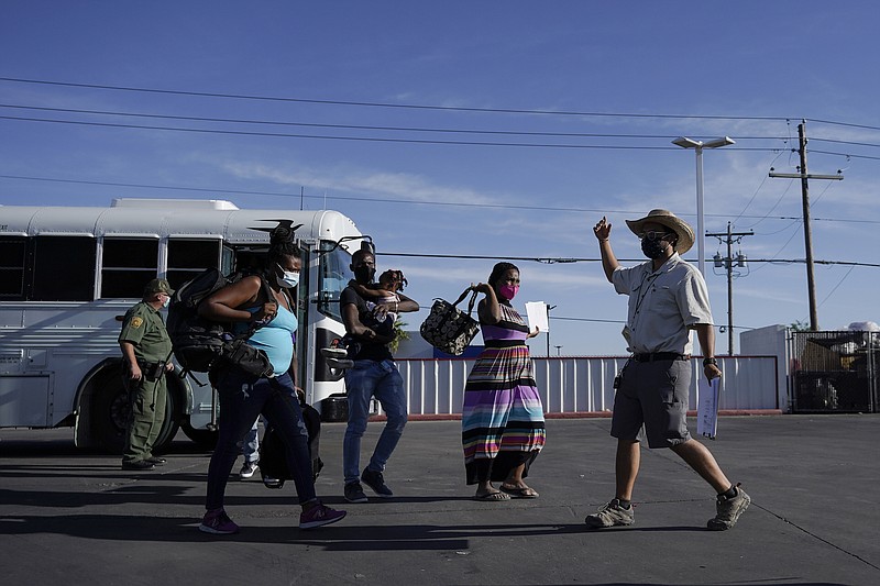 AP Photo by Julio Cortez —In this Wednesday, Sept. 22, 2021, file photo, a member with the Border Humanitarian Coalition, right, guides migrants, mostly from Haiti, as they are released from United States Border Patrol custody upon crossing the Texas-Mexico border in search of asylum in Del Rio, Texas.