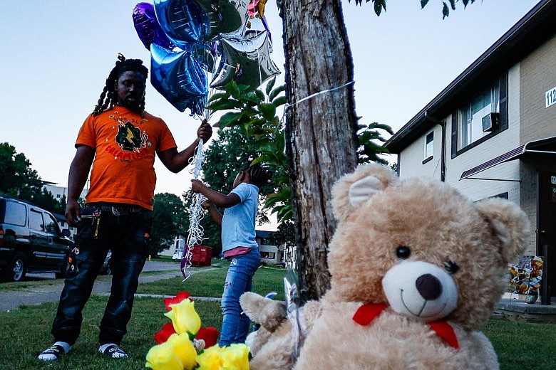Staff photo by Troy Stolt / Ellis Orr and Emoni Orr, 4, bring balloons to a memorial set up in memory of LaBrecia Dews, who Ellis had a child with, on the 1100 block of Grove Street on Tuesday, Sept. 28, 2021 in Chattanooga, Tenn. Dews was one of two women killed during a shooting at a block party on Grove Street late Saturday. 