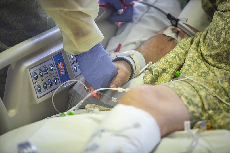 Photo by Kyle Green of The Associated Press / A physician holds the hand of a COVID-19 patient in the Medical Intensive care unit at St. Luke's Boise Medical Center in Boise, Idaho, on Aug. 31, 2021.