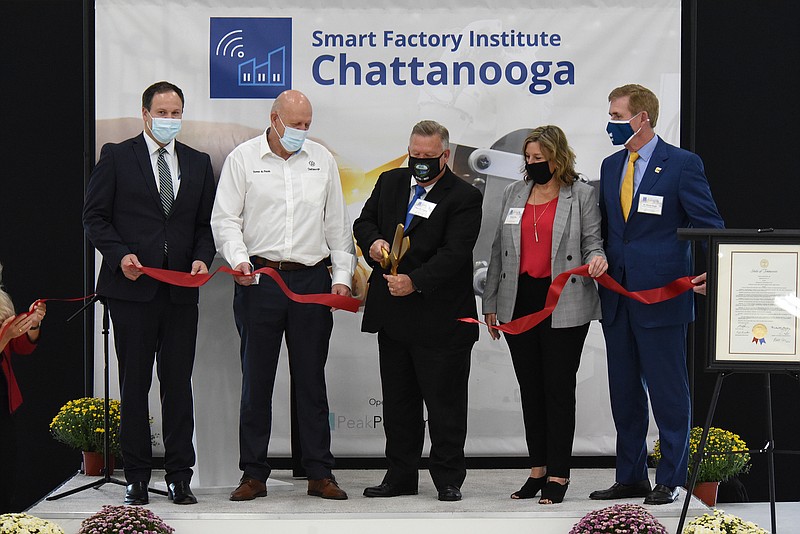 Staff Photo by Matt Hamilton / From left, Bradley Jackson, Thomas du Plessis, Hamilton County Mayor Jim Coppinger, Denise Rice and Dr. Steven Angle participate in the ribbon cutting at the Volkswagen campus on Friday, October 1, 2021. The grand opening and ribbon cutting ceremony were held Friday for the Smart Factory Institute. 