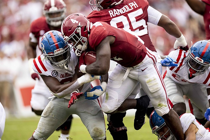 AP photo by Vasha Hunt / Alabama running back Brian Robinson Jr., right, runs by Ole Miss linebacker Lakia Henry during the first half of Saturday's SEC matchup in Tuscaloosa.