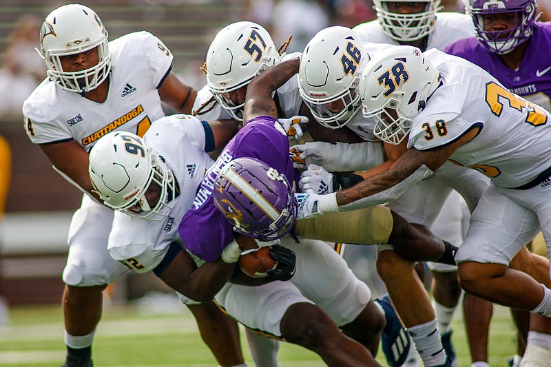 Staff photo by Troy Stolt / Western Carolina running back Kenny Benjamin is tackled by, from left, UTC's Marlon Taylor, Giovanni Reviere, Kam Jones, Ty Boeck and Austin Collier during Saturday's SoCon game at Finley Stadium.