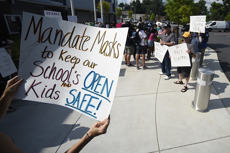 AP file photo by Mike Stewart / A pro-mask demonstrator holds a sign at the Cobb County School Board Headquarters on Aug. 12, in Marietta, Georgia. Tennessee leads the country in school closures due to COVID-19, and Georgia is No. 2.