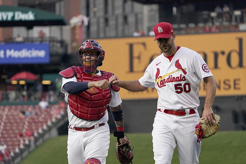 St. Louis Cardinals starting pitcher Adam Wainwright (50) gets a fist bump from catcher Yadier Molina as they walk to the dugout before the start of a baseball game against the Milwaukee Brewers Tuesday, Aug. 17, 2021, in St. Louis. (AP Photo/Jeff Roberson)