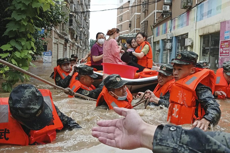 FILE - In this Thursday, Aug. 12, 2021 file photo, paramilitary police work to evacuate people trapped in a flooded area in Suizhou in central China's Hubei Province. Flooding in central China continued to cause havoc in both cities and rural areas. According to a United Nations report released on Tuesday, Oct. 5, 2021, much of the world is unprepared for the floods, hurricanes and droughts expected to worsen with climate change and urgently needs better warning systems to avert water-related disasters. (Chinatopix via AP)