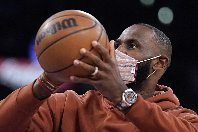 Photo by Mark J. Terrill of The Associated Press / Los Angeles Lakers forward LeBron James, who was not playing, shoots during a timeout in the second half of a preseason NBA basketball game against the Brooklyn Nets on Oct. 3, 2021, in Los Angeles.