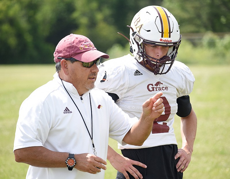 Staff photo by Matt Hamilton / Grace Academy football coach Bob Ateca talks with senior Cooper Knecht, the team's starting quarterback and a defensive standout, during practice at Christ United Methodist Church this past May. The Golden Eagles' switch to TSIAA eight-man football this season due to a smaller roster has been a big success, with their 7-0 record so far the best start in the program's 18-year history.