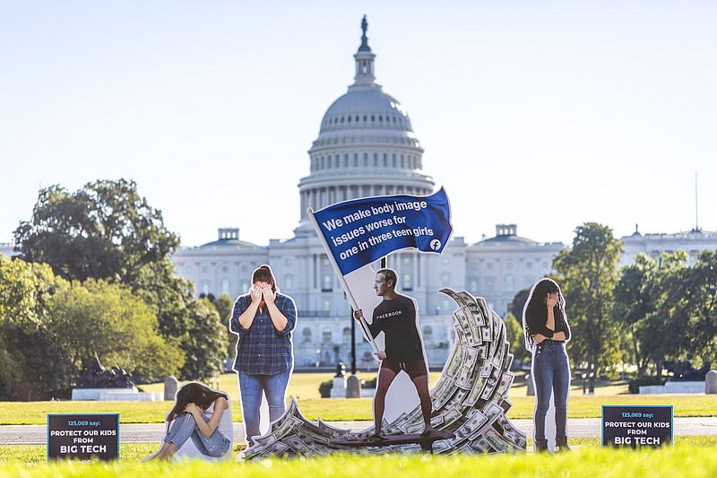 Photo by Eric Kayne of The Associated Press for SumofUS / SumOfUs erected a 7-foot visual protest outside the U.S. Capitol depicting Facebook CEO Mark Zuckerberg surfing on a wave of cash, while young women surround him appearing to be in distress on Thursday, Sept. 30, 2021, in Washington.