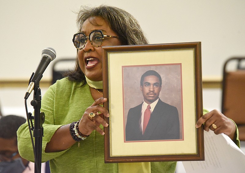 Staff file photo by Matt Hamilton / Audrey Ramsey holds a photo of her late brother Donald Ramsey as she speaks in Tuesday's 'Stop the Violence' community event at the Kingdom Center of Olivet Baptist Church.