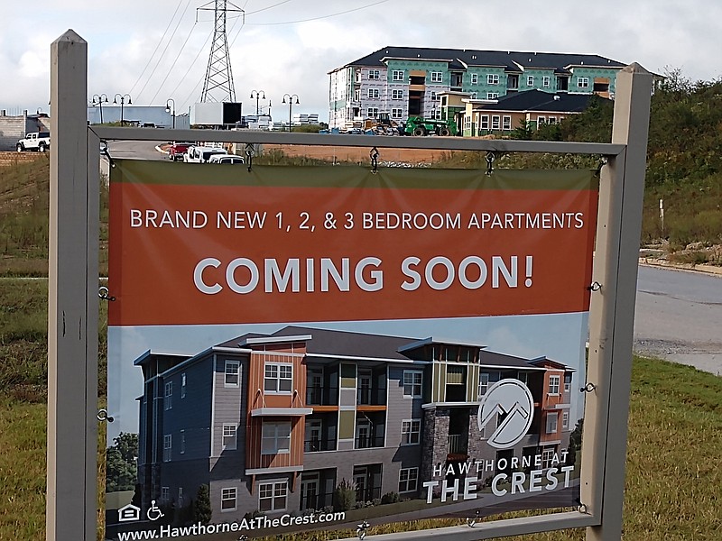 Staff photo by Mike Pare / A sign shows new apartments coming to Hawthorne at The Crest off Apison Pike in Collegedale with construction of the units in the background.