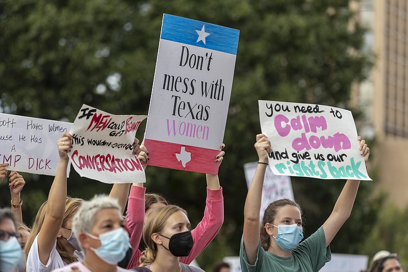 In this Oct. 2, 2021, file photo, people attend the Women's March ATX rally, at the Texas State Capitol in Austin, Texas. A federal judge has ordered Texas to suspend a new law that has banned most abortions in the state since September. The order Wednesday by U.S. District Judge Robert Pitman freezes for now the strict abortion law known as Senate Bill 8. (AP Photo/Stephen Spillman, File)