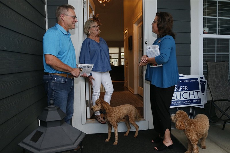 Jennifer Feucht, right, candidate for Olentangy Local Board of Education, delivers campaign flyers and yard signs to Brad, left, and Tina Krider Thursday, Oct. 7, 2021, in Westerville, Ohio. (AP Photo/Jay LaPrete)


