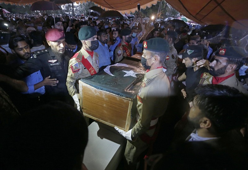 Soldiers carry the national flag-wrapped casket of Pakistani nuclear scientist Abdul Qadeer Khan during his funeral prayer, in Islamabad, Pakistan, Sunday, Oct. 10, 2021. Khan, a controversial figure known as the father of Pakistan's nuclear bomb, died Sunday of COVID-19 following a lengthy illness, his family said. He was 85. (AP Photo/Anjum Naveed)