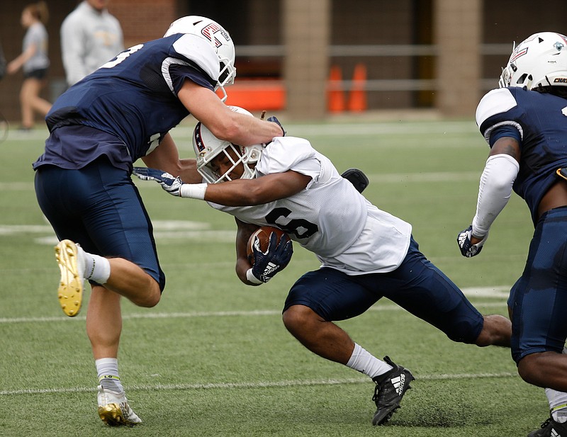 Staff photo by Doug Strickland / Chattanooga's Kohl Henke, left, tackles teammate Jeffery Wood during the University of Tennessee at Chattanooga spring football scrimmage at Finley Stadium on Saturday, March 30, 2019, in Chattanooga, Tenn.