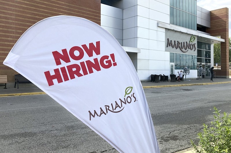 A sign in the parking lot of Mariano's grocery store advertises the availability of jobs Friday, Oct. 8, 2021, in Chicago. One reason America's employers are having trouble filling jobs was starkly illustrated in a report Tuesday, Oct. 12: Americans are quitting in droves. (AP Photo/Charles Rex Arbogast)