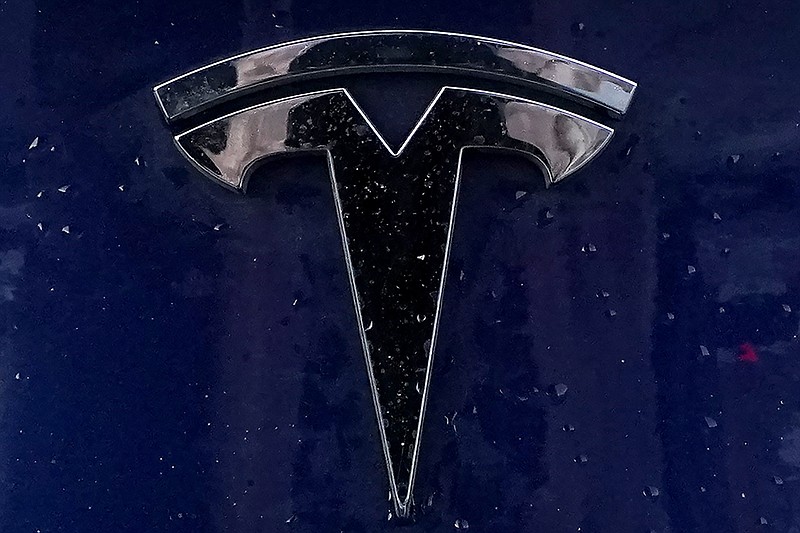 FILE - A Tesla electric vehicle emblem is affixed to a passenger vehicle Sunday, Feb. 21, 2021, in Boston. U.S. highway safety investigators want to know why Tesla didn't file recall paperwork when it updated Autopilot software so it would do a better job spotting parked emergency vehicles. In a letter sent to Tesla on Tuesday, Oct. 12, the National Highway Traffic Safety Administration told the electric car maker that it has to do a recall if an over-the-internet update mitigates a safety defect. (AP Photo/Steven Senne, File)