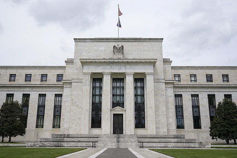 FILE - This May 4, 2021, file photo shows the Federal Reserve building in Washington. Federal Reserve officials agreed at their last meeting that if the economy continued to improve, they could start reducing their monthly bond purchases as soon as next month and bring them to an end by the middle of 2022. The discussion was revealed in the minutes of the Fed’s Sept. 21-22 meeting, released Wednesday, Oct. 13, 2021. (AP Photo/Patrick Semansky, File)