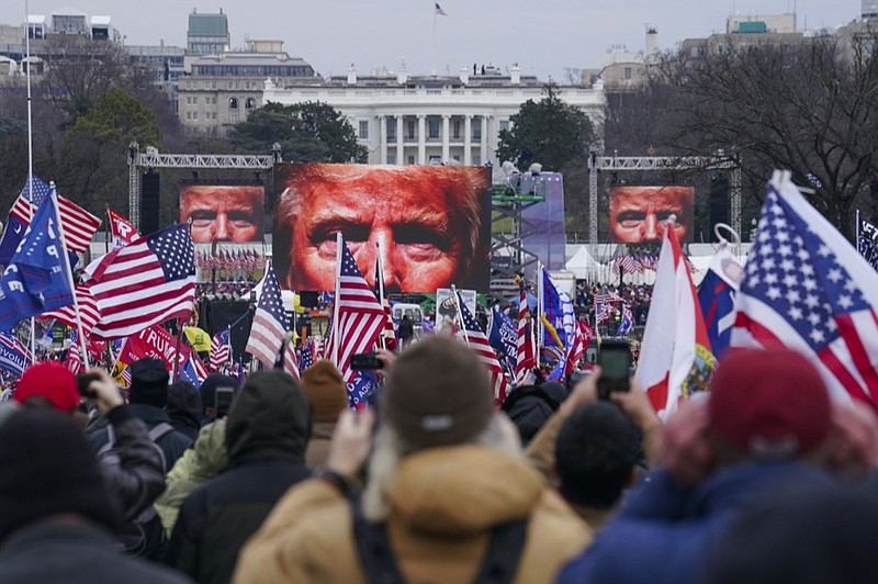 FILE - In this Jan. 6, 2021, file photo, the face of President Donald Trump appears on large screens as supporters participate in a rally in Washington. (AP Photo/John Minchillo, File)


